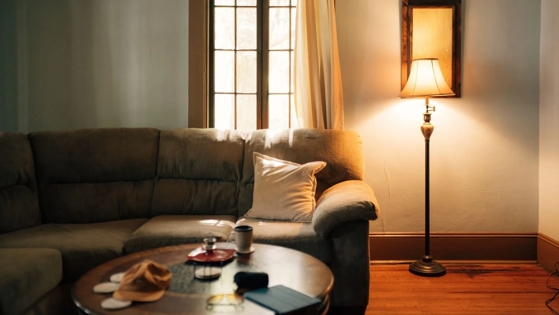 A lamp lit on a side table in the evening