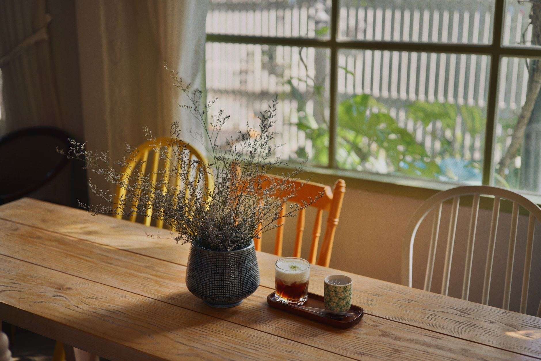 A wooden kitchen table by a window in morning light