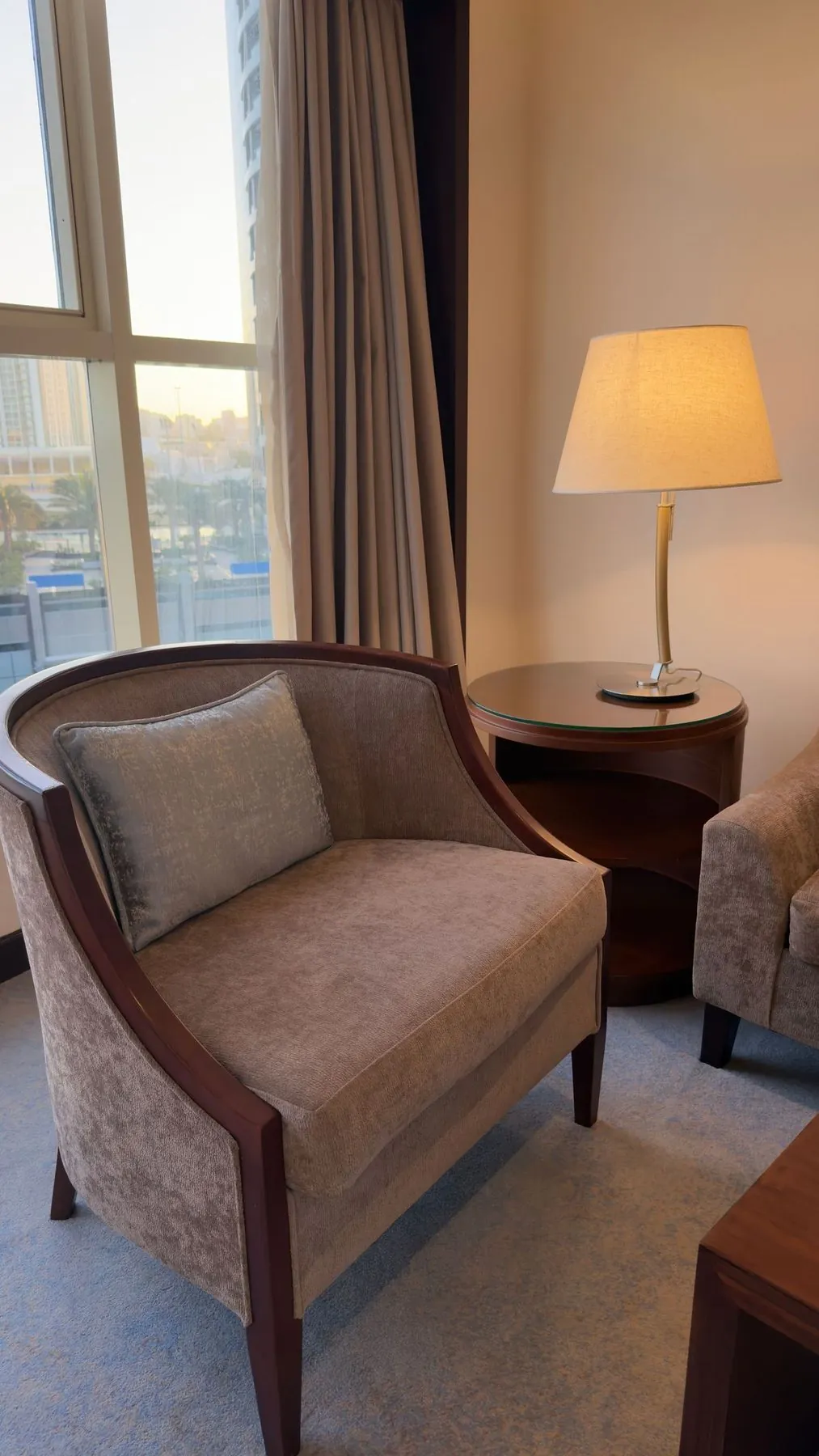 An armchair by a window with a lamp