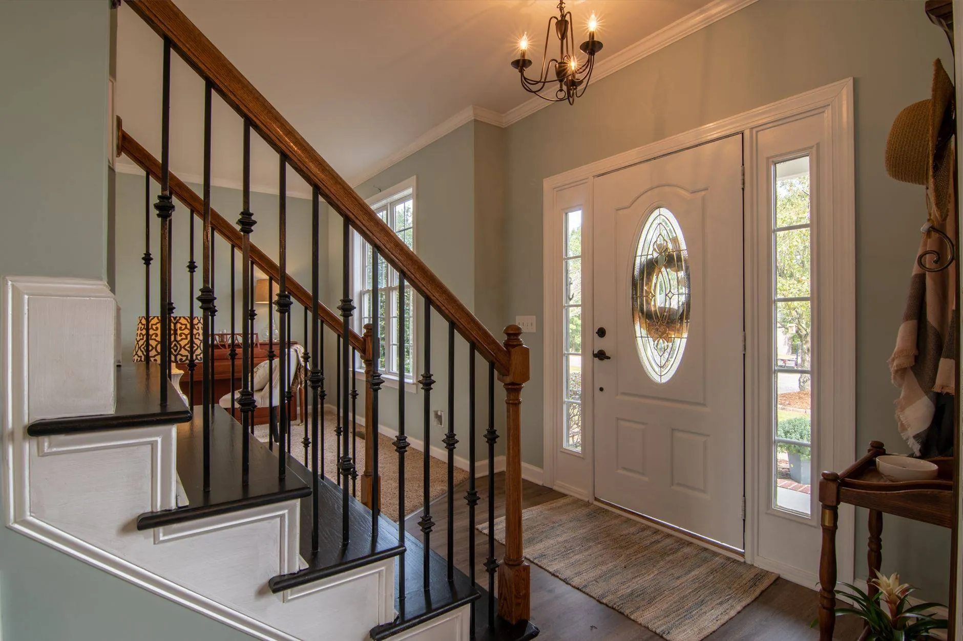 A front hall with a staircase and the door open to morning light