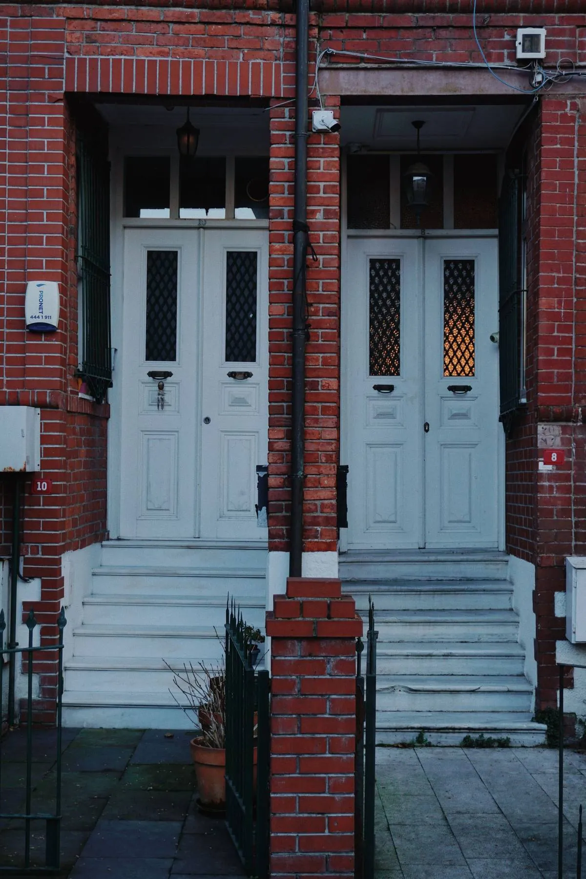 Brick rowhouse steps up to a white front door